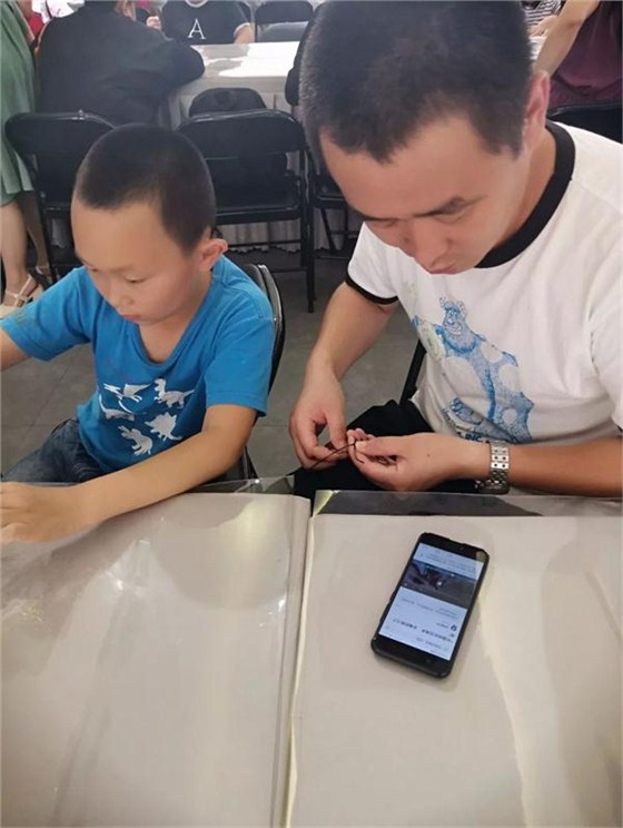 學(xué)生與家長共同制作扇子