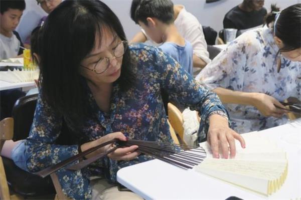 中國(guó)制扇工藝大師、蘇州制扇技藝傳承人盛春帶領(lǐng)中外友人學(xué)制扇